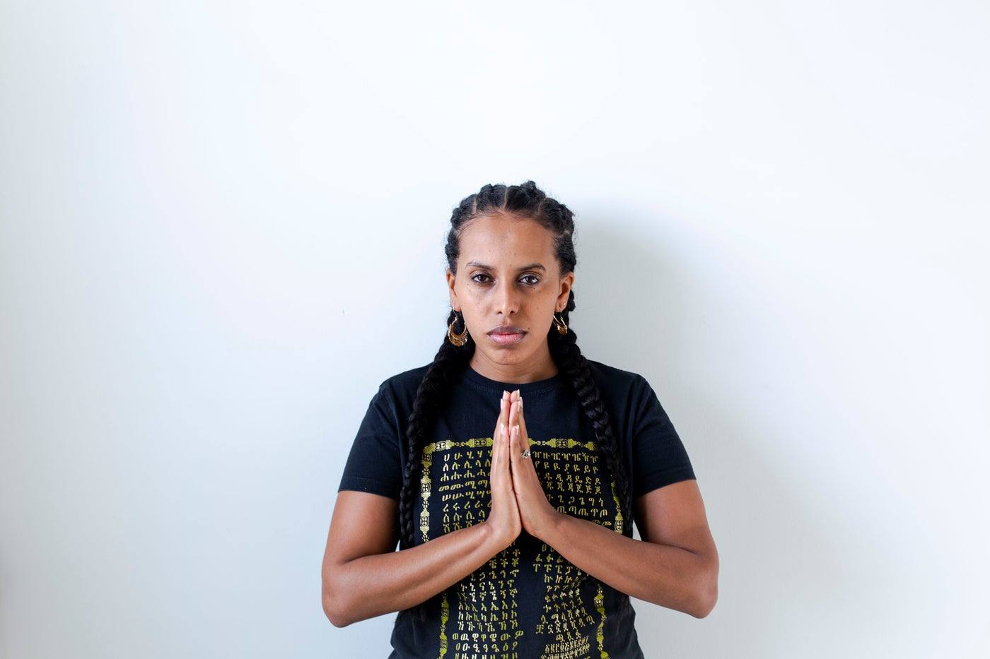 A young woman praying with her hands together